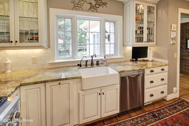 kitchen featuring light stone counters, sink, and stainless steel dishwasher