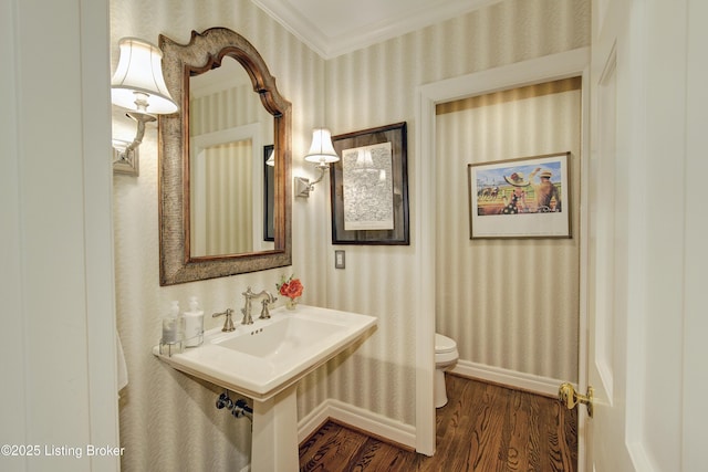 bathroom with crown molding, wood-type flooring, and toilet