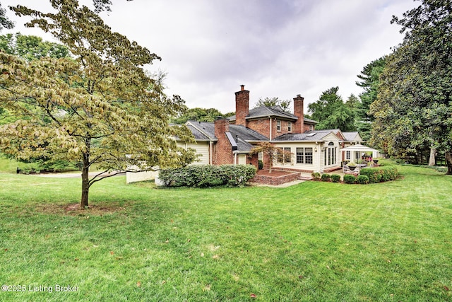 back of house with a lawn and a patio