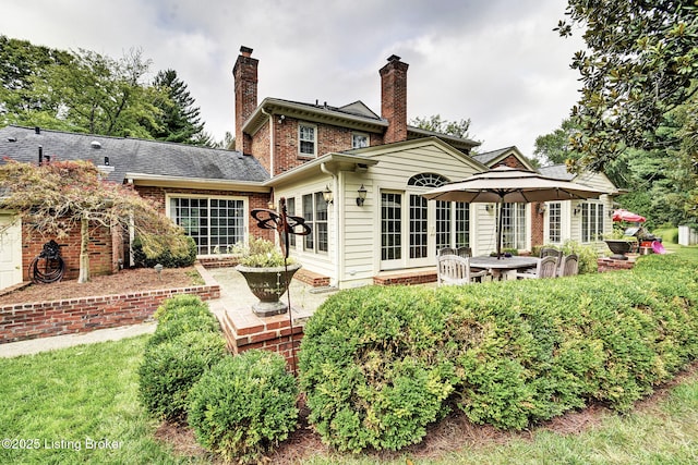 rear view of house featuring a lawn, a patio area, and french doors