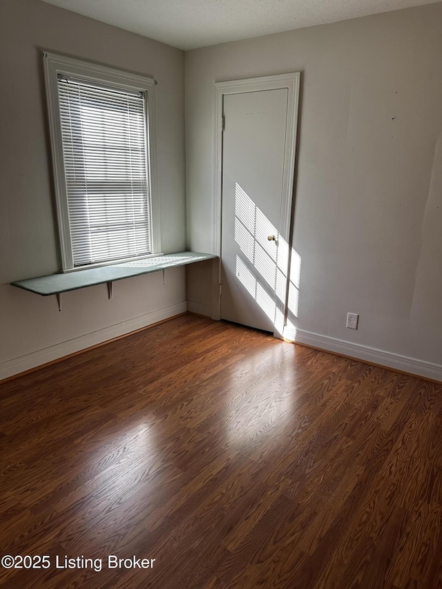 spare room featuring dark wood-type flooring