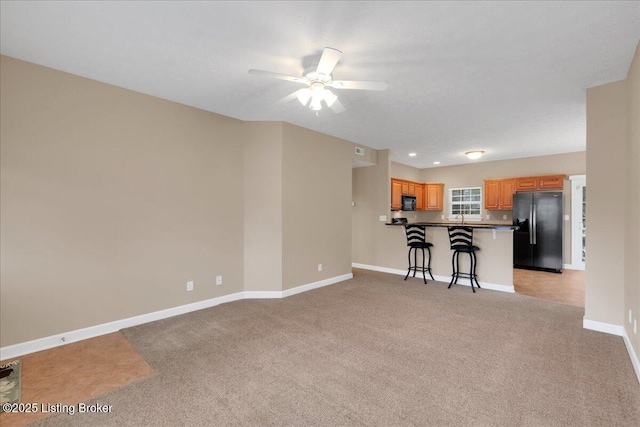 unfurnished living room with ceiling fan and light colored carpet