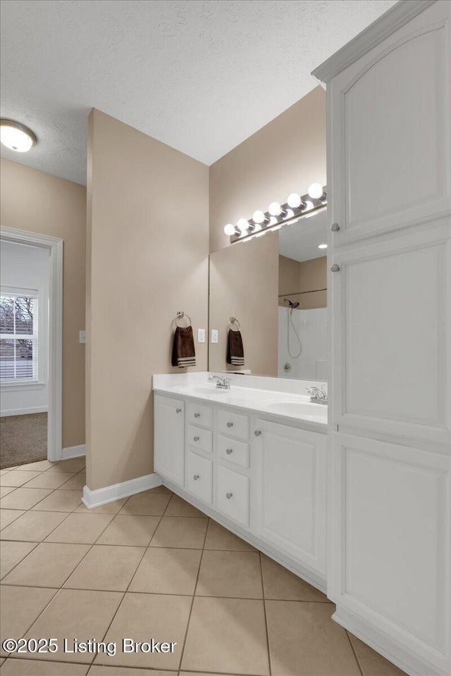 bathroom featuring a shower, tile patterned floors, a textured ceiling, and vanity