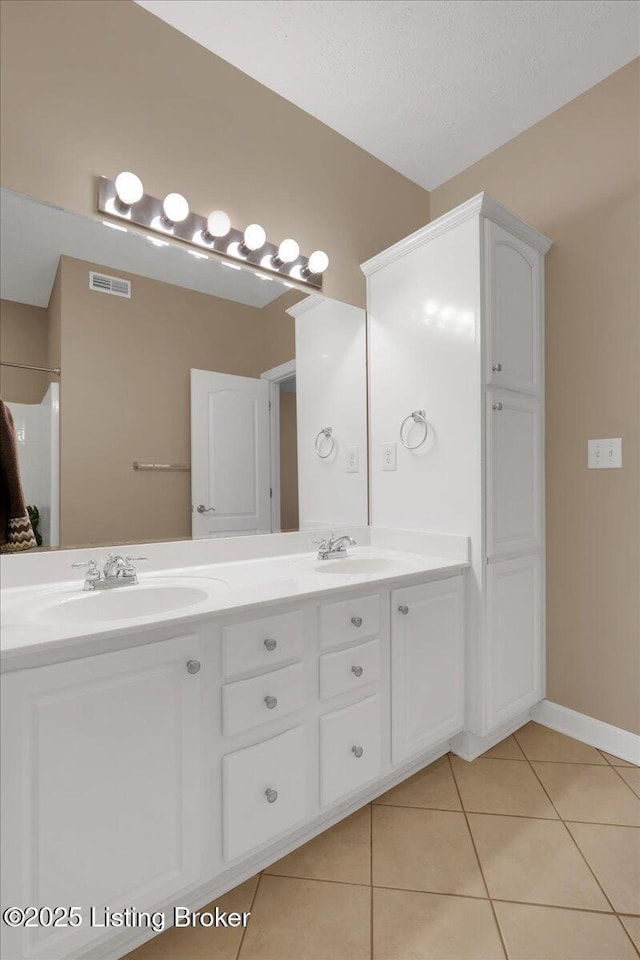 bathroom featuring vanity, tile patterned flooring, and a textured ceiling