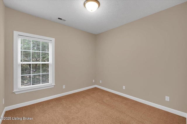 carpeted empty room with a textured ceiling