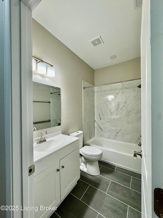 full bathroom with tiled shower / bath combo, vanity, and toilet