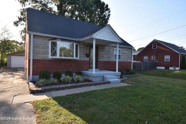 bungalow-style home with an outbuilding, a garage, and a front yard