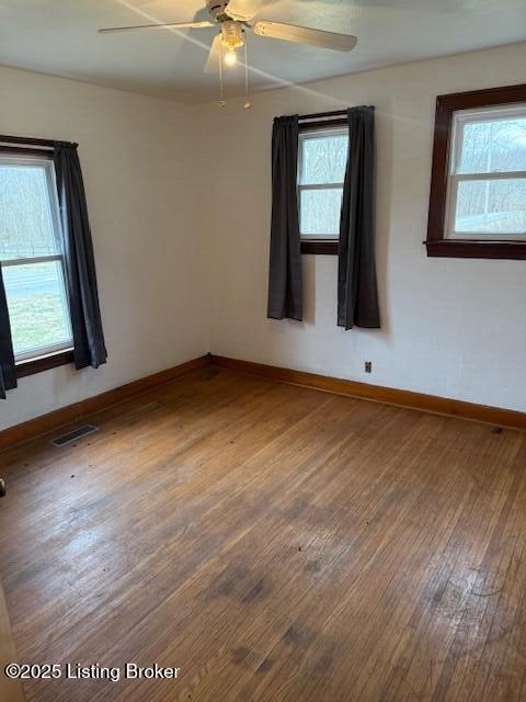 empty room with ceiling fan and hardwood / wood-style floors