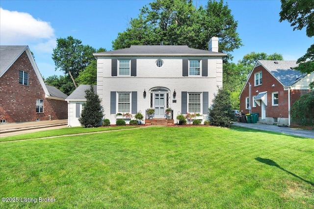 colonial inspired home featuring a front lawn