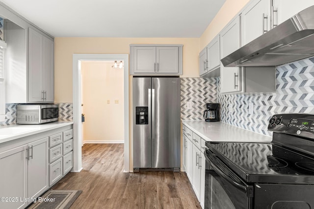 kitchen with sink, appliances with stainless steel finishes, gray cabinetry, tasteful backsplash, and dark hardwood / wood-style flooring