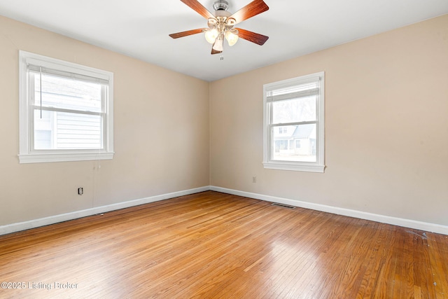 empty room with ceiling fan and light hardwood / wood-style flooring