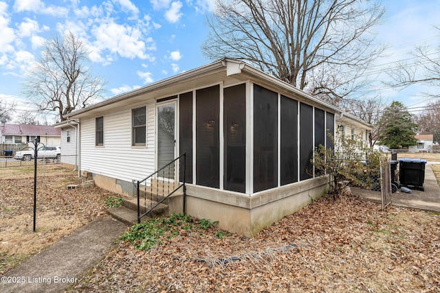 view of property exterior with a sunroom