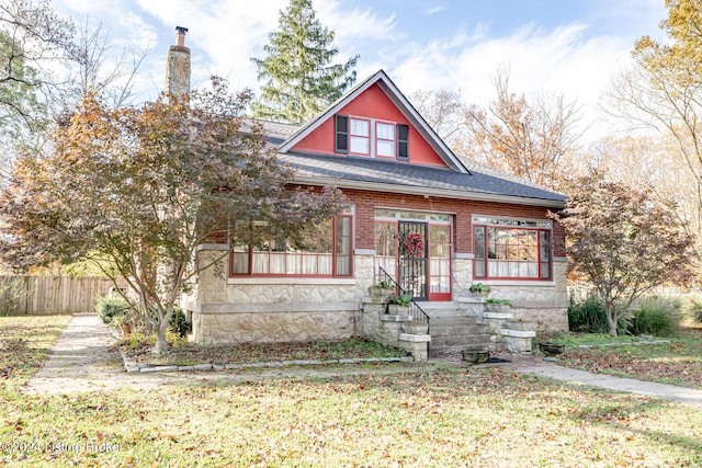 bungalow-style house featuring stone siding, brick siding, a shingled roof, and fence