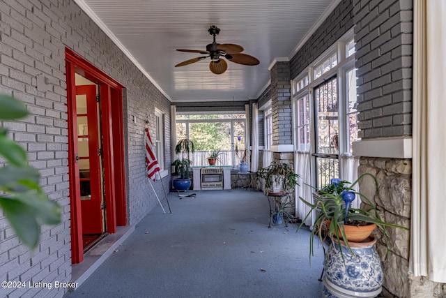 unfurnished sunroom featuring ceiling fan