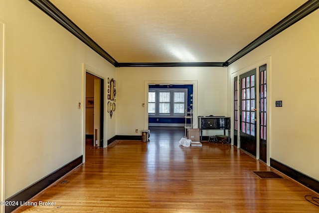 interior space with ornamental molding, wood-type flooring, and a textured ceiling