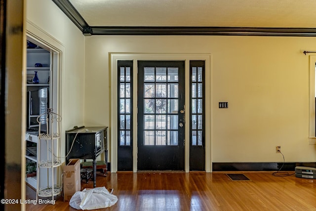 foyer with ornamental molding and wood-type flooring