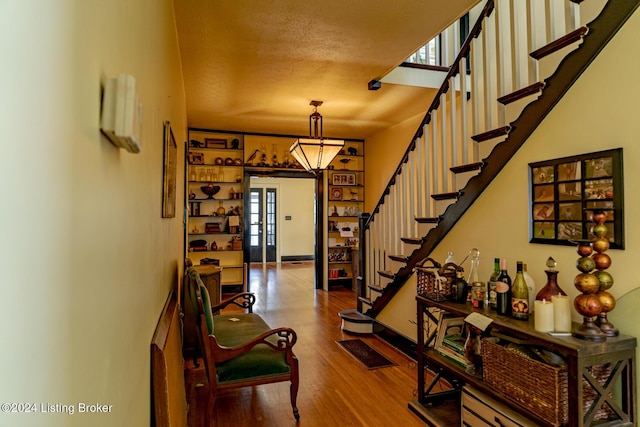 foyer entrance with wood-type flooring, french doors, and a textured ceiling