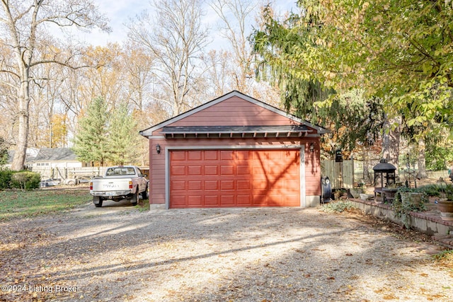 detached garage featuring fence