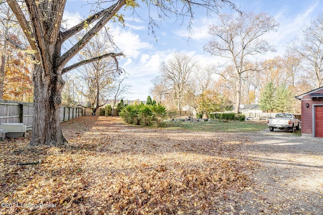 view of yard with driveway and fence