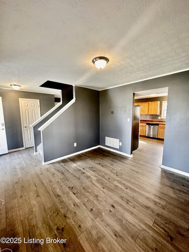 unfurnished living room with hardwood / wood-style floors and a textured ceiling