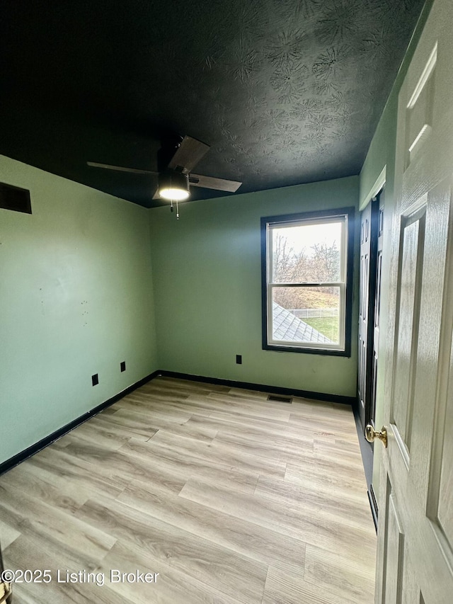 spare room featuring ceiling fan, a textured ceiling, and light wood-type flooring