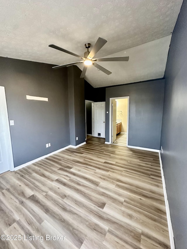 unfurnished bedroom with ceiling fan, ensuite bathroom, light hardwood / wood-style floors, and a textured ceiling