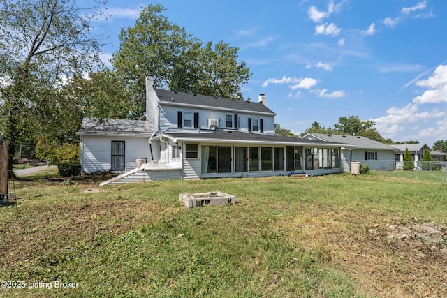 rear view of house with a yard and a sunroom