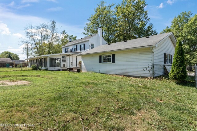 back of house featuring a sunroom and a yard