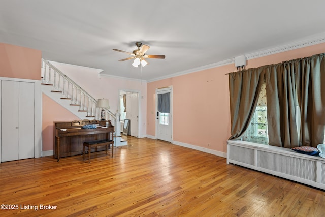 interior space with light hardwood / wood-style flooring, radiator heating unit, ornamental molding, and ceiling fan