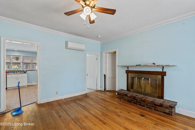 unfurnished living room featuring an AC wall unit, sink, light wood-type flooring, and a brick fireplace