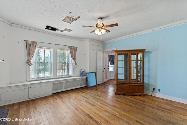 spare room featuring ceiling fan, radiator heating unit, a textured ceiling, and light wood-type flooring