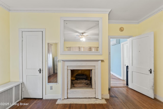 unfurnished living room featuring crown molding, dark wood-type flooring, radiator heating unit, and a wall unit AC