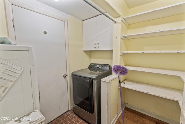 clothes washing area with cabinets and washing machine and dryer