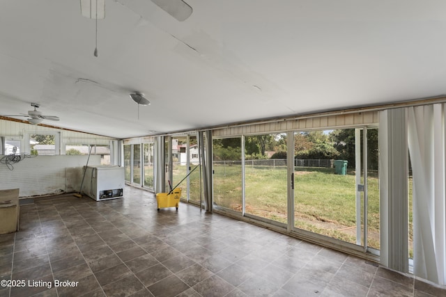 unfurnished sunroom with ceiling fan, vaulted ceiling, and a healthy amount of sunlight