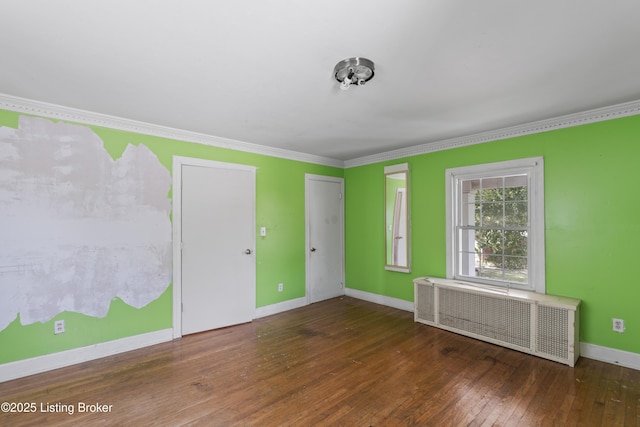 empty room with radiator, ornamental molding, and dark hardwood / wood-style floors