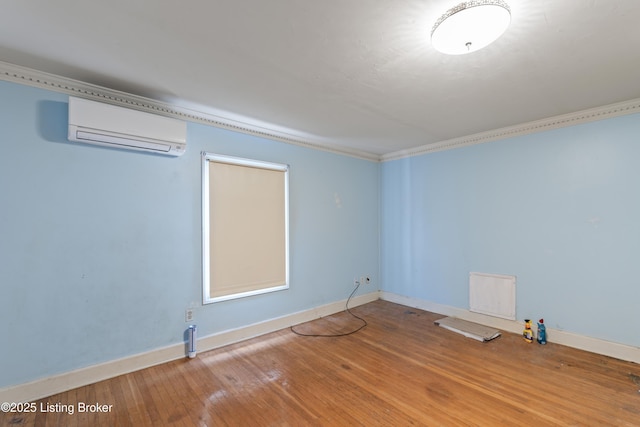 spare room with hardwood / wood-style flooring, ornamental molding, and a wall mounted AC