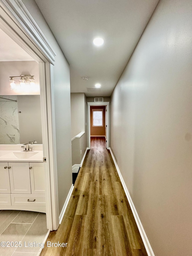 hall with hardwood / wood-style flooring and sink