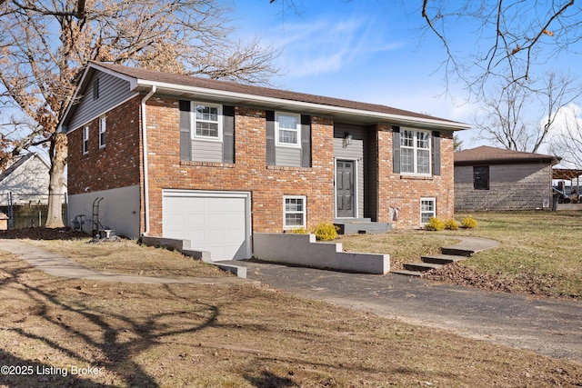 raised ranch with a garage and a front yard