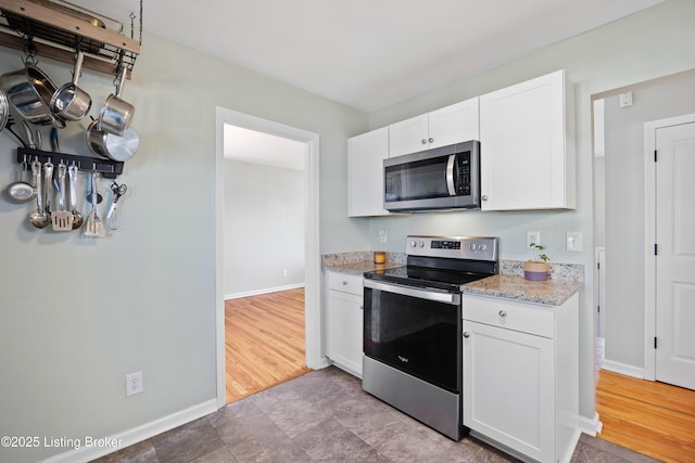 kitchen featuring light stone countertops, white cabinets, and appliances with stainless steel finishes