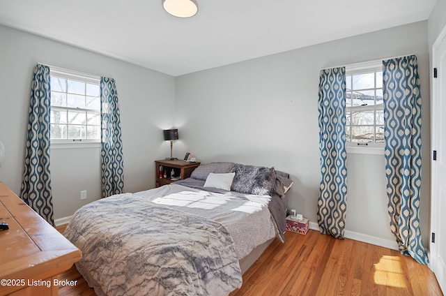 bedroom featuring multiple windows and light wood-type flooring