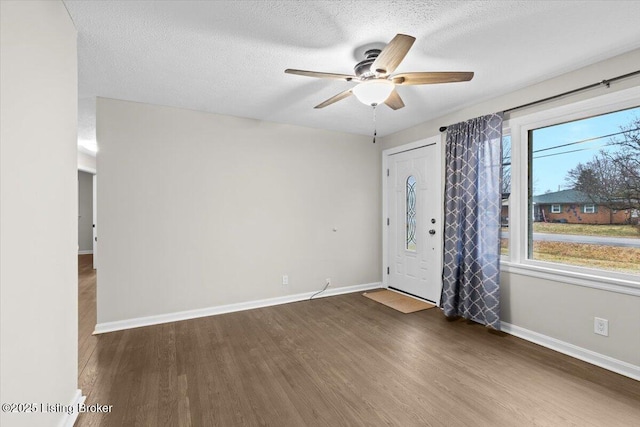 entrance foyer featuring ceiling fan, a textured ceiling, and dark hardwood / wood-style flooring