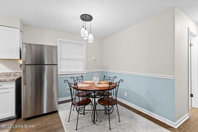 dining space featuring hardwood / wood-style floors and a textured ceiling