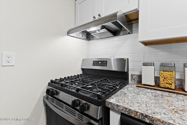 kitchen featuring decorative backsplash, stainless steel gas range oven, light stone countertops, and white cabinets