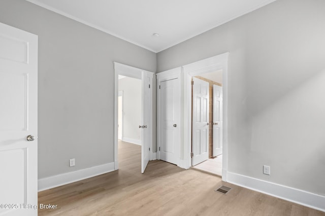 unfurnished bedroom with ornamental molding and light hardwood / wood-style floors