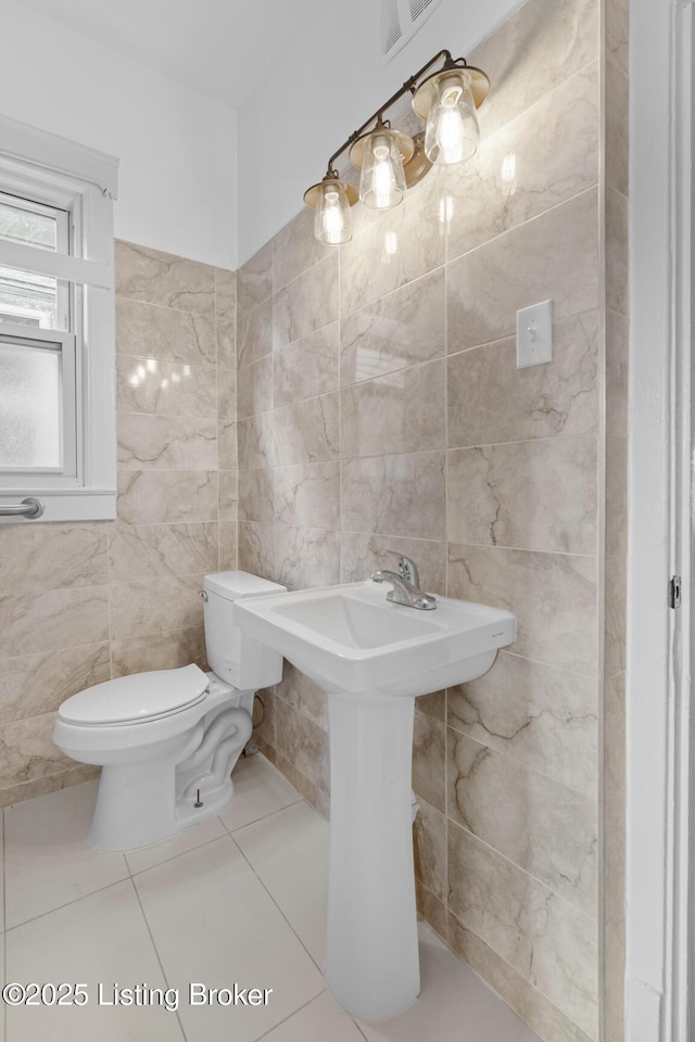 bathroom featuring tile walls and toilet