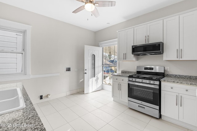 kitchen featuring sink, stainless steel range with gas cooktop, light stone countertops, and white cabinets