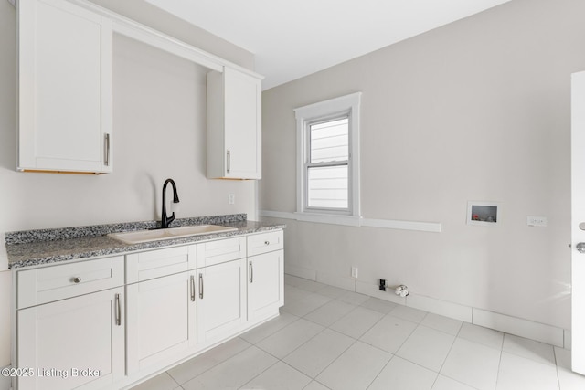 kitchen featuring sink, dark stone countertops, white cabinets, and light tile patterned floors