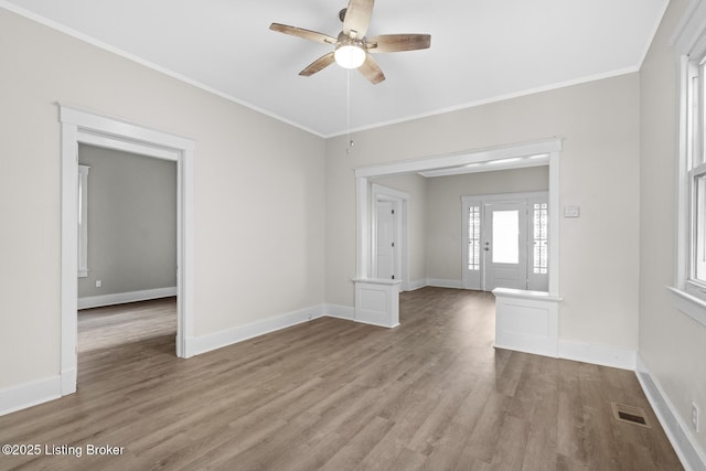 unfurnished room featuring ornamental molding, ceiling fan, and light wood-type flooring