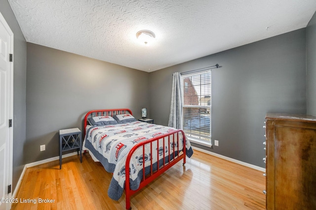 bedroom featuring hardwood / wood-style floors and a textured ceiling