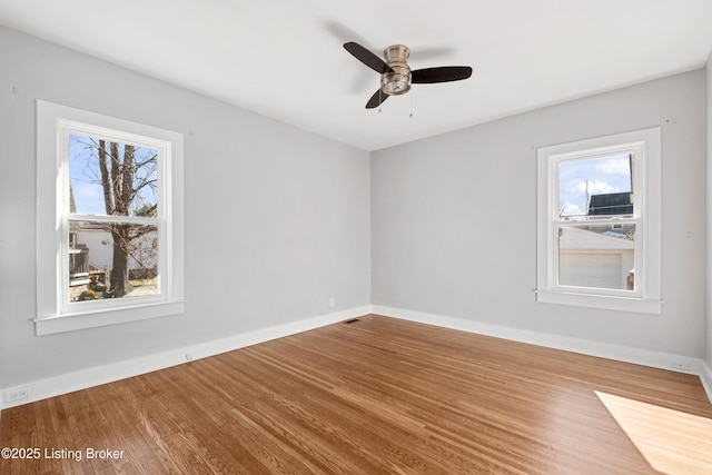 empty room with hardwood / wood-style flooring and ceiling fan